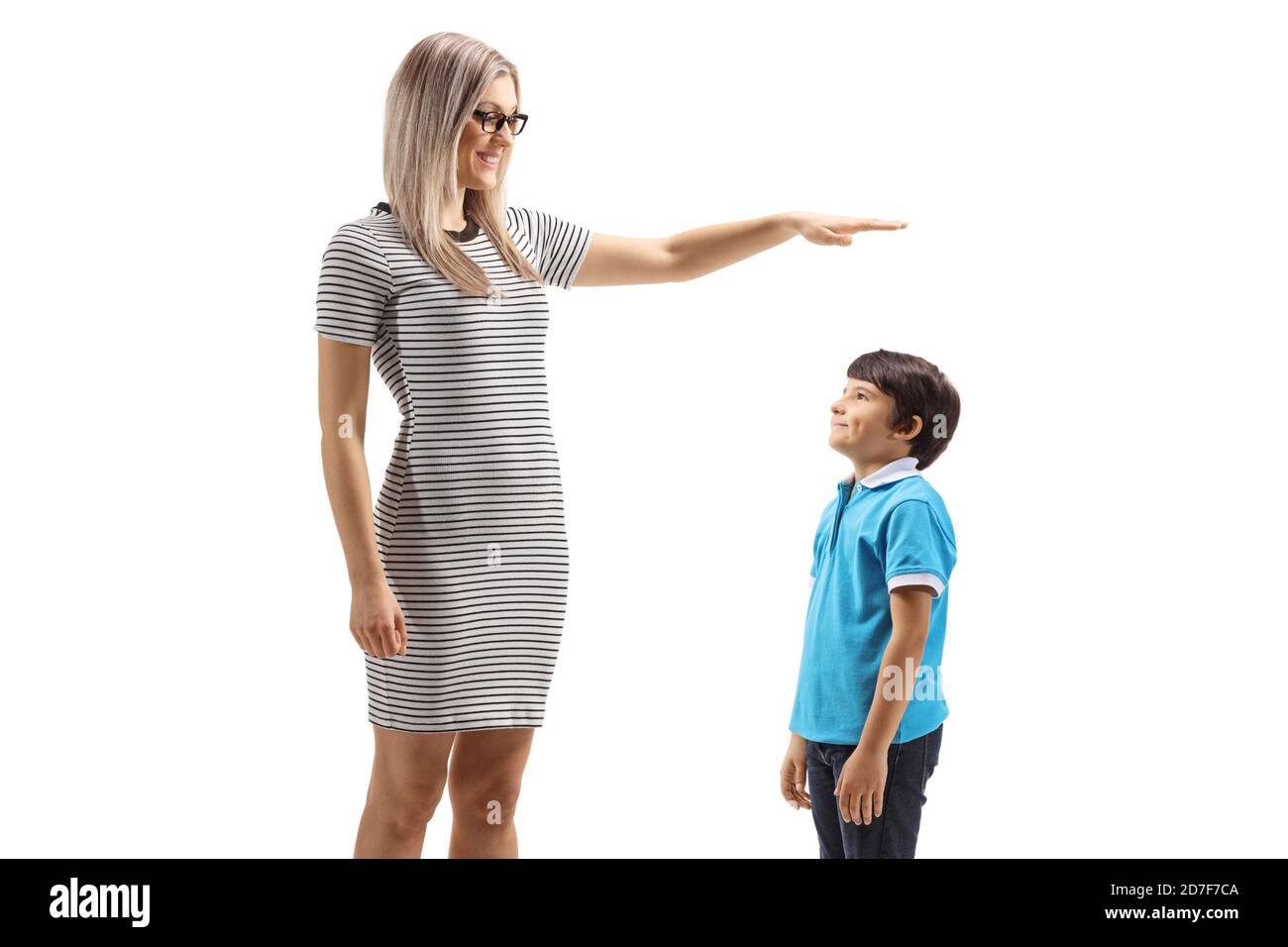 Junge Frau gestikuliert mit der Hand und zeigt die Höhe der Ein Junge auf weißem Hintergrund isoliert Stockfoto