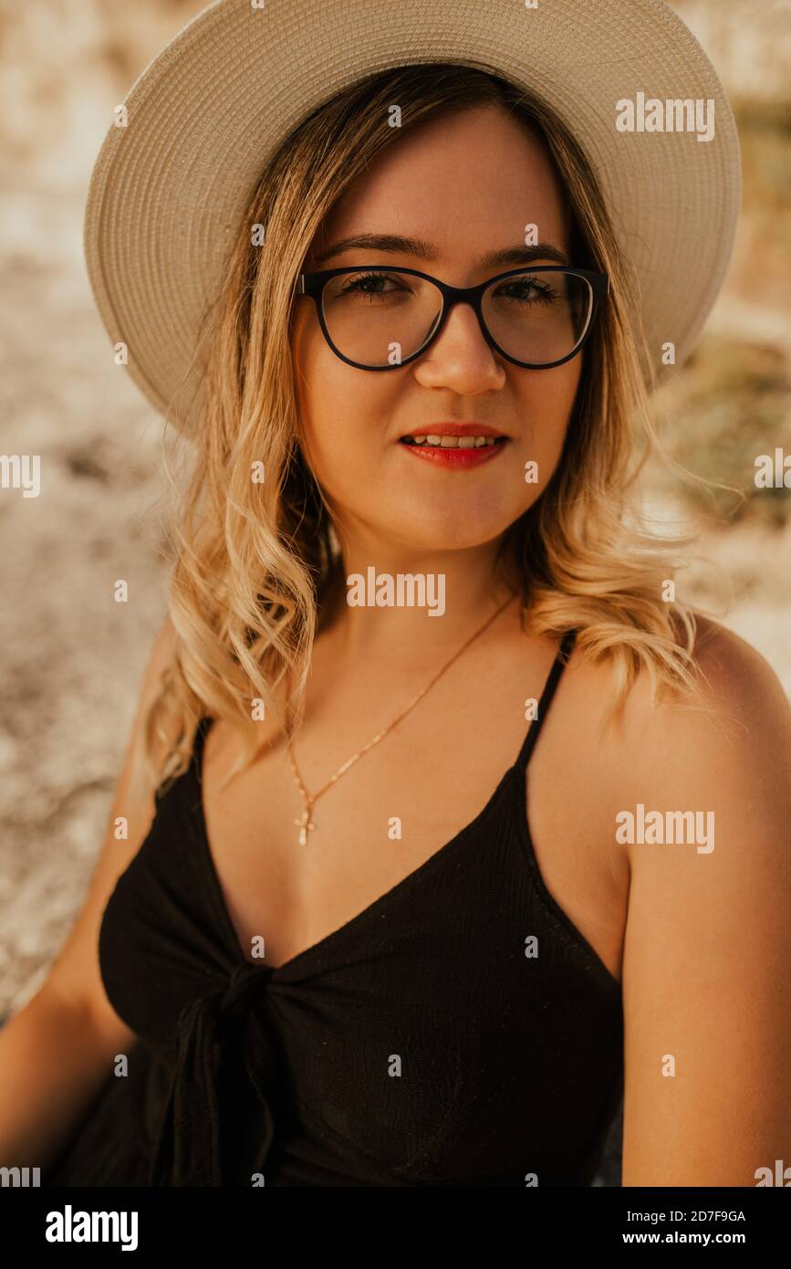 Hellhäutige Frau in Brille und Hut Stockfoto