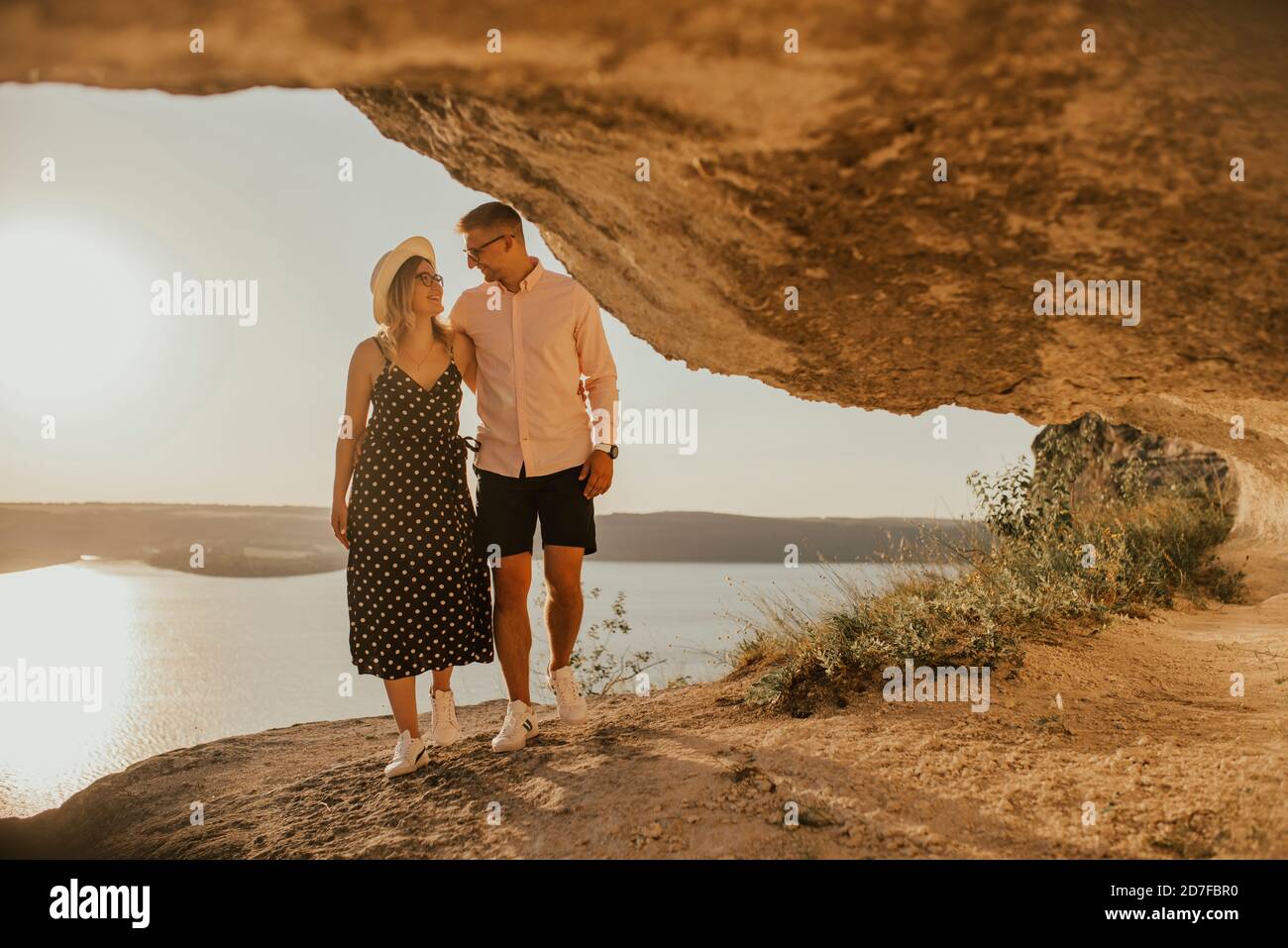 Mann und Frau im Hut gehen entlang Felsen über dem Klippe Stockfoto