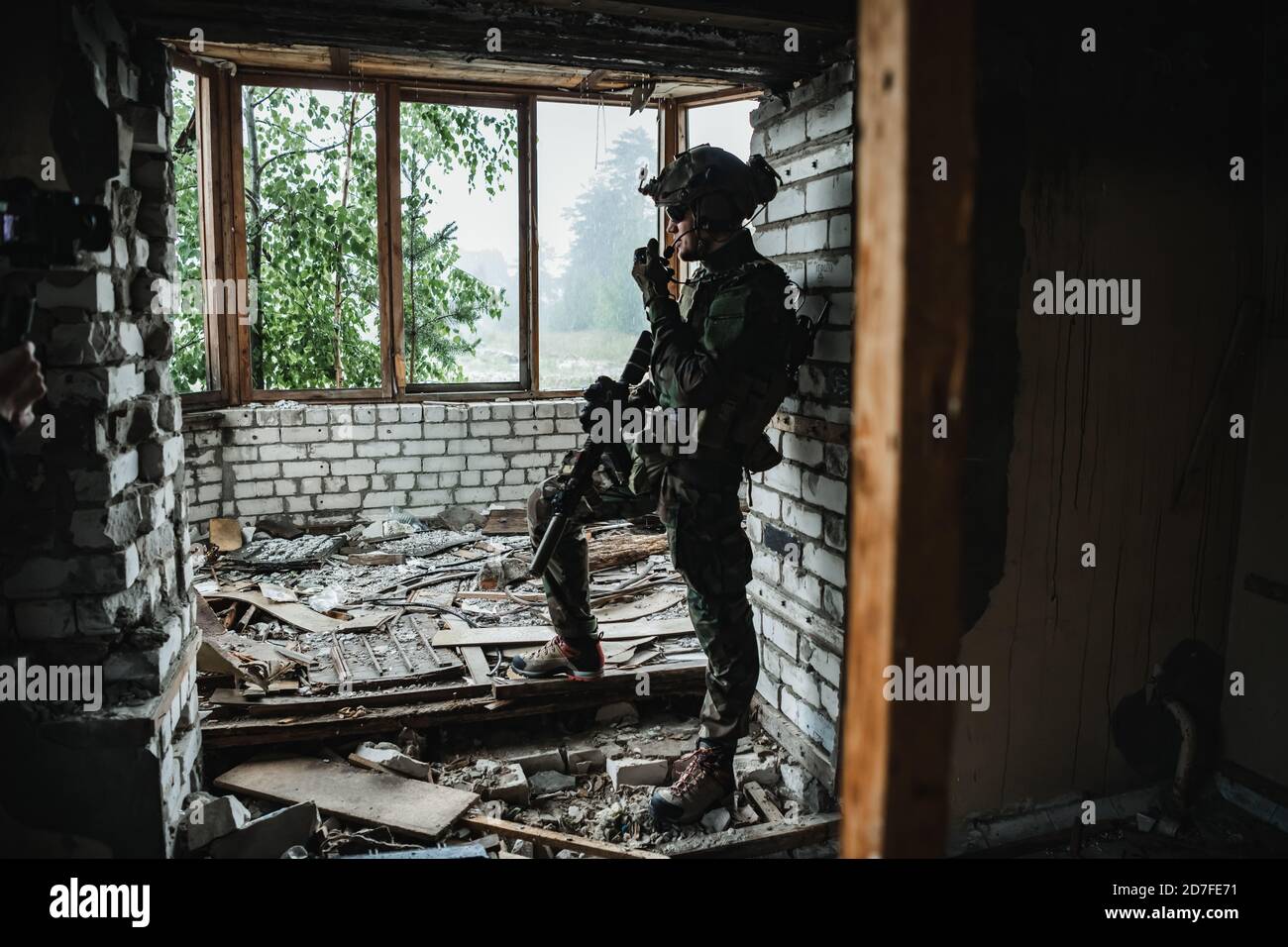 Soldat im Gespräch auf dem Walkie-Talkie im Gebäude, militärische Konzept Stockfoto