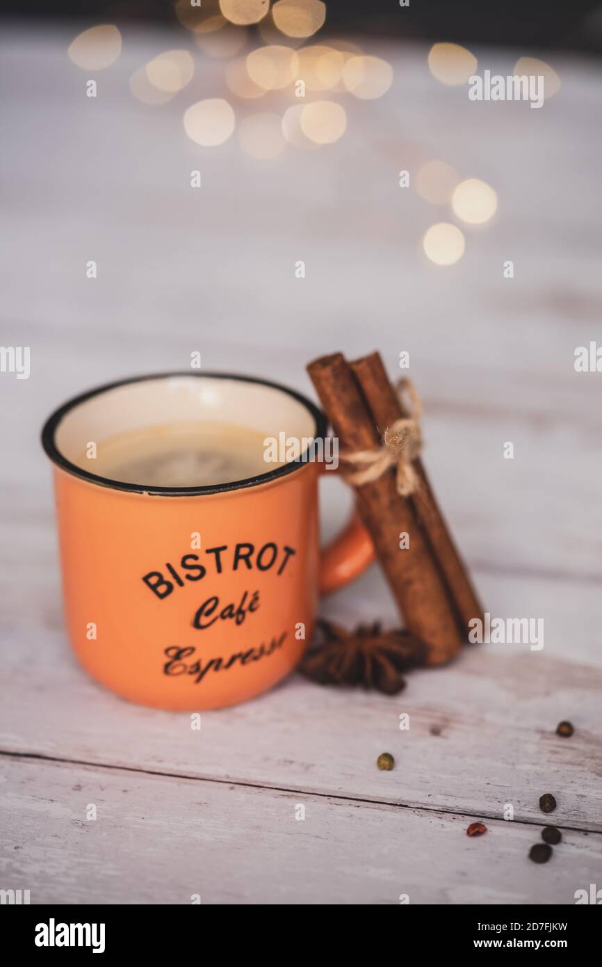 Vintage orange Kaffeetasse mit Zimt und Sternanis auf weißem Holzhintergrund. weihnachtliche Gewürze. Stockfoto