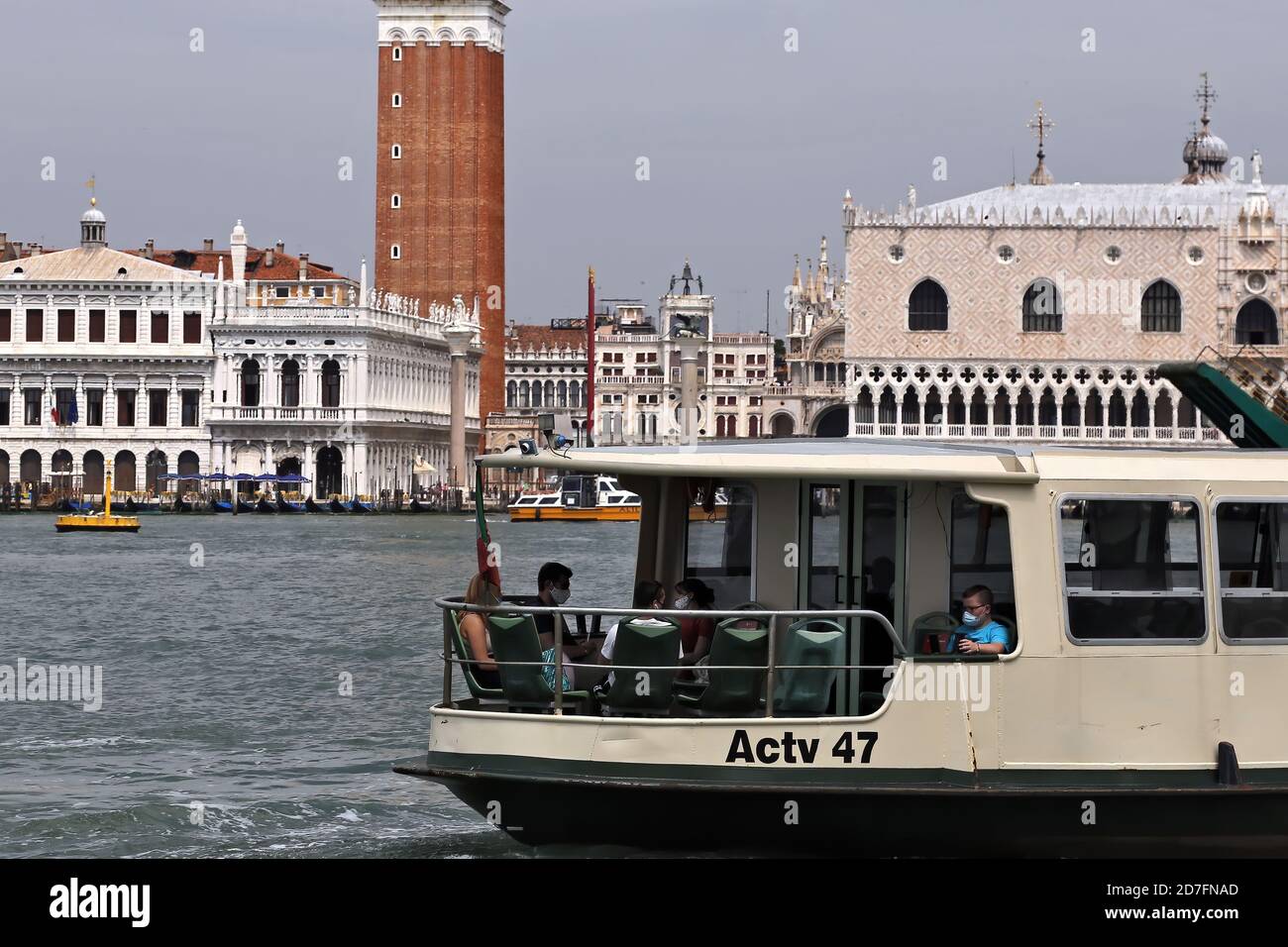 Venedig, Italien. Juni 25, 2020. Menschen und erste Touristen mit Schutzmasken auf einem Boot, das vor dem Markusplatz während der Covid-19-Periode vorbeifährt Stockfoto