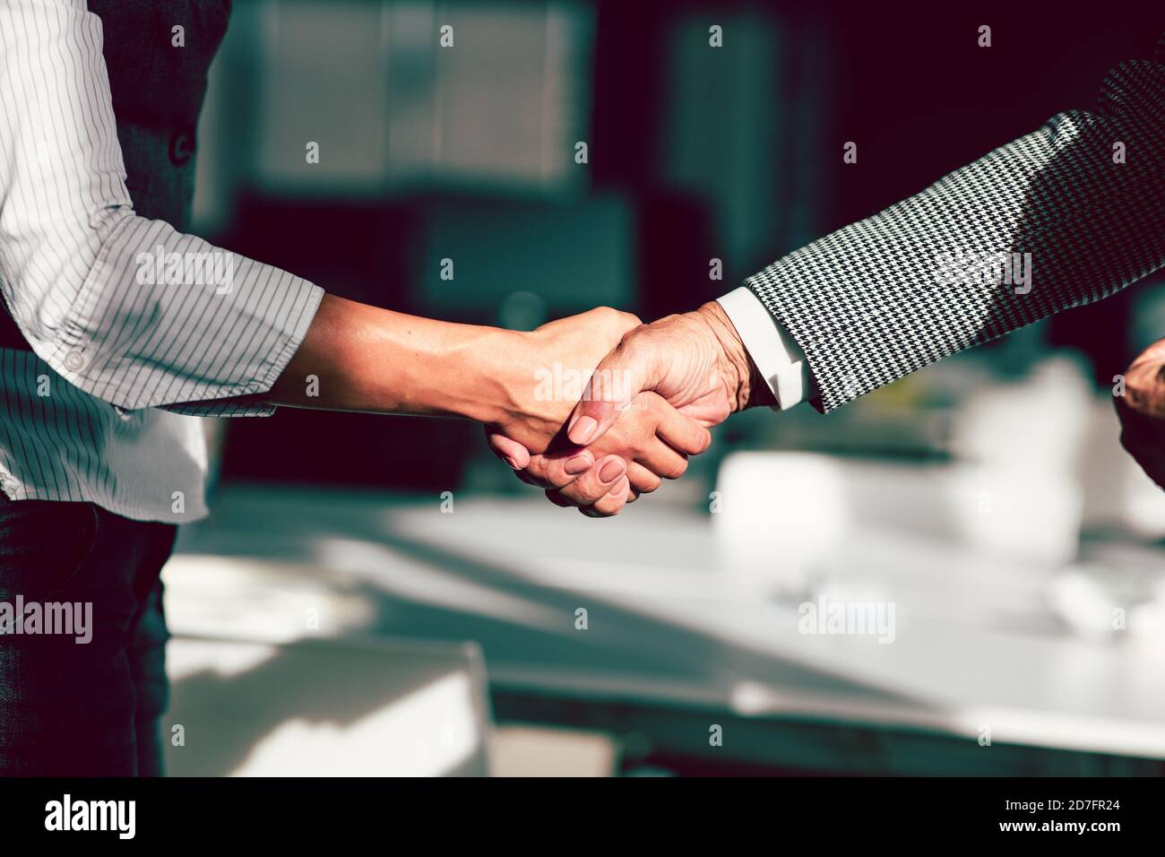 Geschäftsmann und Geschäftsfrau schüttelten sich die Hände über dem Schreibtisch Stockfoto