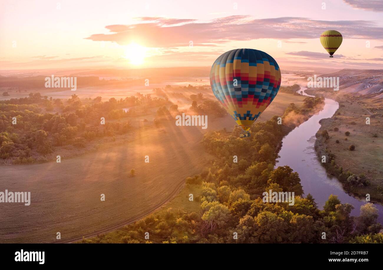 Heißluftballon über dem Fluss bei Sonnenuntergang. Reisen, Freiheit, Abenteuer, Erkundung, extremes Konzept. Stockfoto