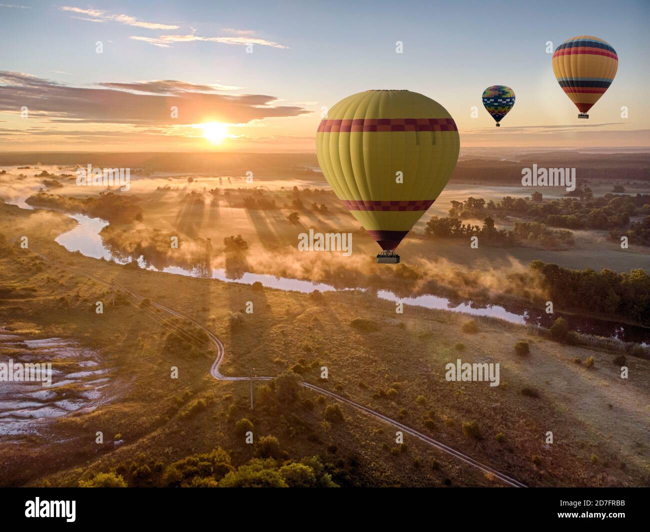 Heißluftballon über dem Fluss bei Sonnenuntergang. Reisen, Freiheit, Abenteuer, Erkundung, extremes Konzept. Stockfoto