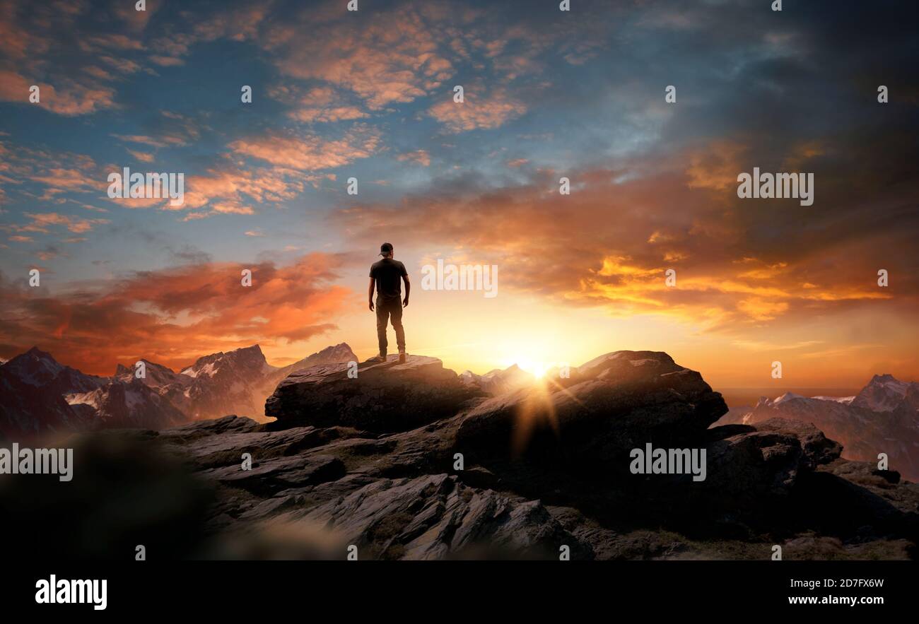 Ein Mann, der auf einem Berg steht, als die Sonne untergeht. Ziele, Hoffnungen und Ziele Konzept. Bildkomposition. Stockfoto