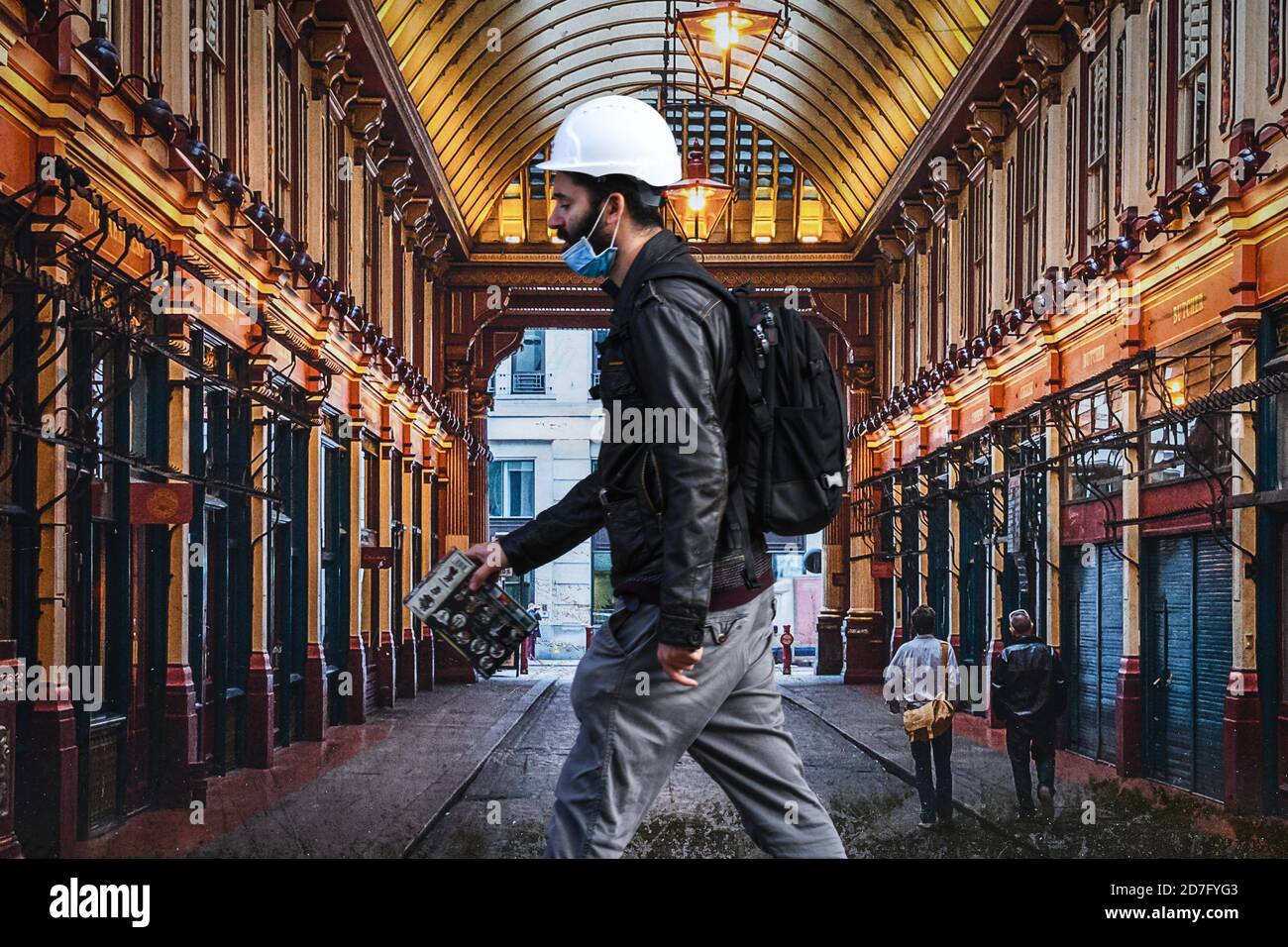 Eine Person, die einen Hut und eine Gesichtsmaske am Kinn trägt, geht an einem Boarding in einer Straße im Stadtzentrum von Swansea vorbei, während die Menschen in Wales in Richtung Livin gehen Stockfoto