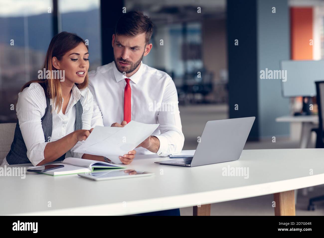 Ein paar fleißige Kollegen, die in einem modernen Büro zusammenarbeiten Stockfoto