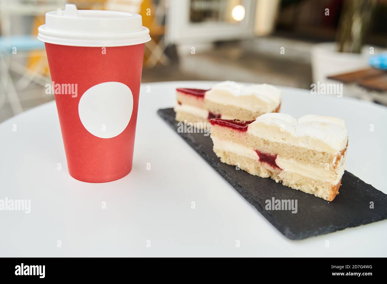 Papiertasse Kaffee mit Dessert. Kaffee mit Kuchen auf weißem Tisch Stockfoto