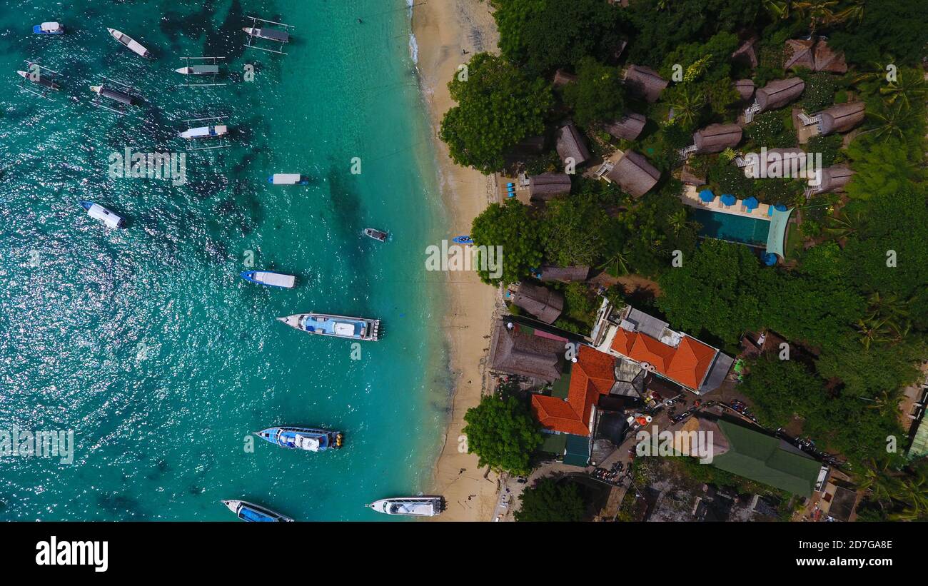 Schöne Aussicht vom Himmel, Lembongan Insel. Meersand, blaues Wasser, schwarze Korallen und auch schwimmende ein Boot. Stockfoto