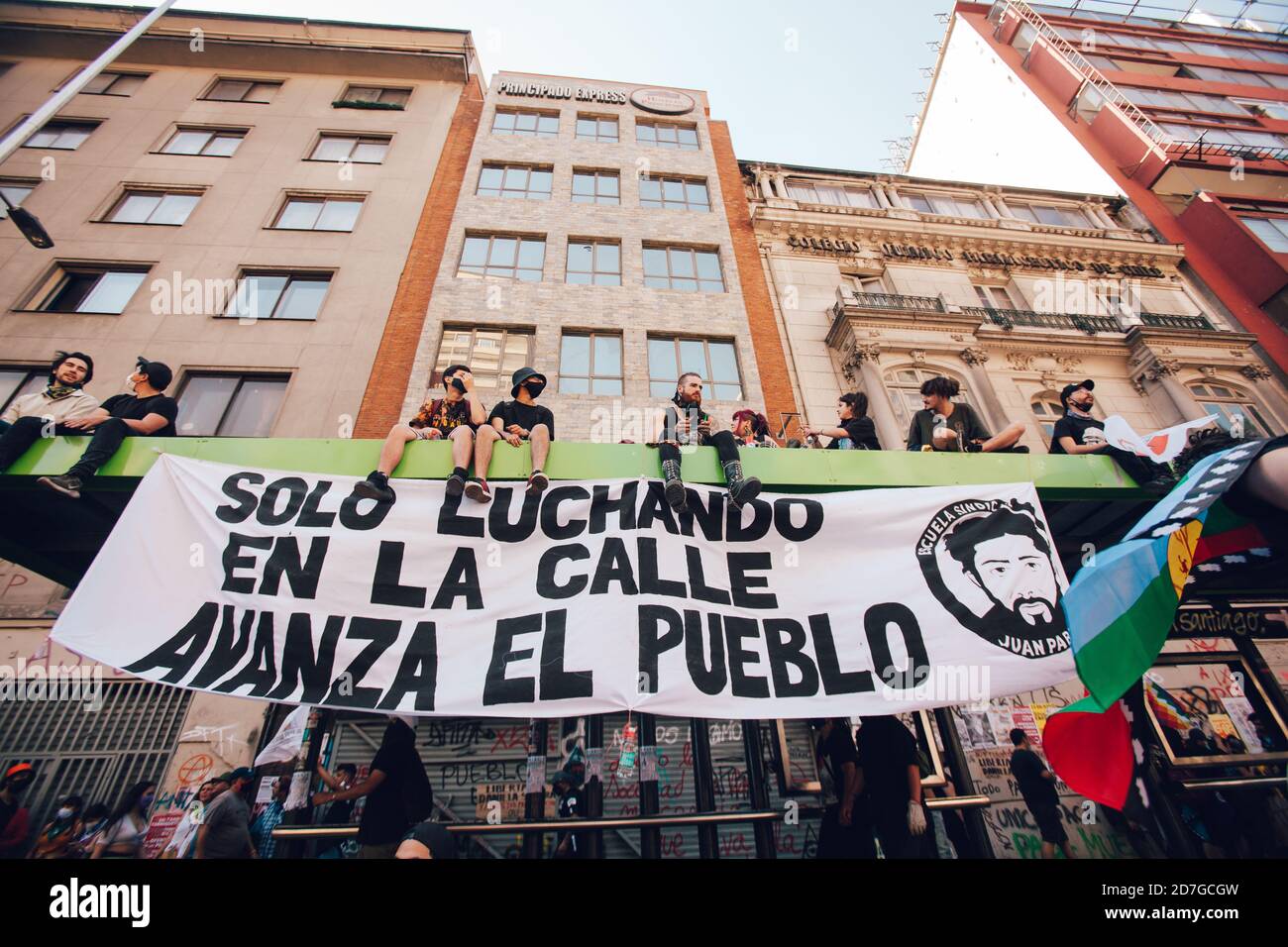 SANTIAGO, CHILE-18. OKTOBER 2020 - Demonstranten auf dem Dach einer Bushaltestelle mit einem Schild mit der Aufschrift "nur auf der Straße kämpfen die Menschen voran" Stockfoto