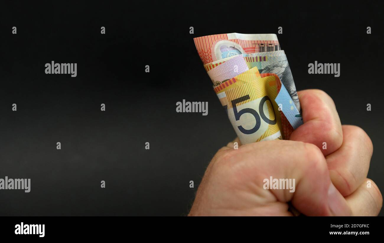 Eine Nahaufnahme eines Wads von Geldscheinen in einer fest geballten Faust. 50 fünfzig als Hauptbezeichnung. Glücksspiel Zahltag gewinnen Ausgaben sparen Verkäufe Stockfoto