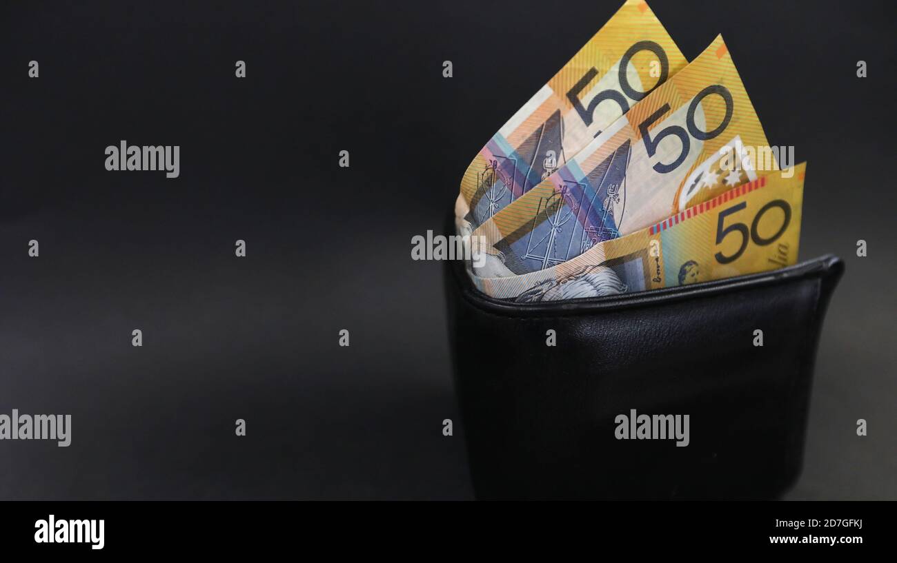 Nahaufnahme Blick nach unten auf eine isolierte schwarze Geldbörse oder Brieftasche mit 50 fünfzig-Dollar-Scheine. Zahltag Finanzbudget. Persönliche Finanzen Ausgaben ein Budget Stockfoto
