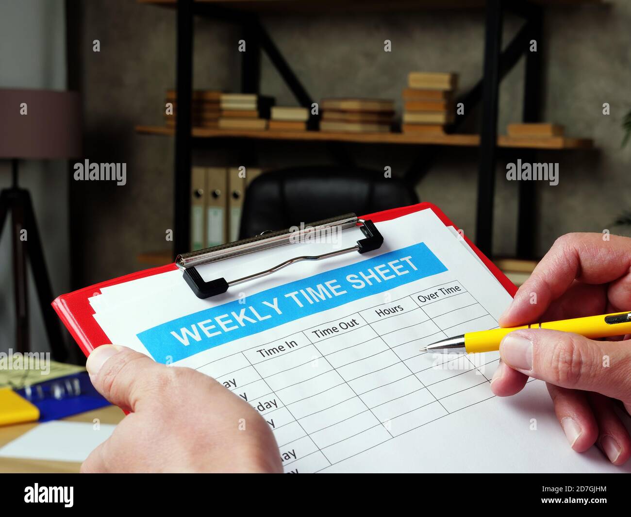 Der Manager füllt die wöchentliche Zeitliste aus. Stockfoto