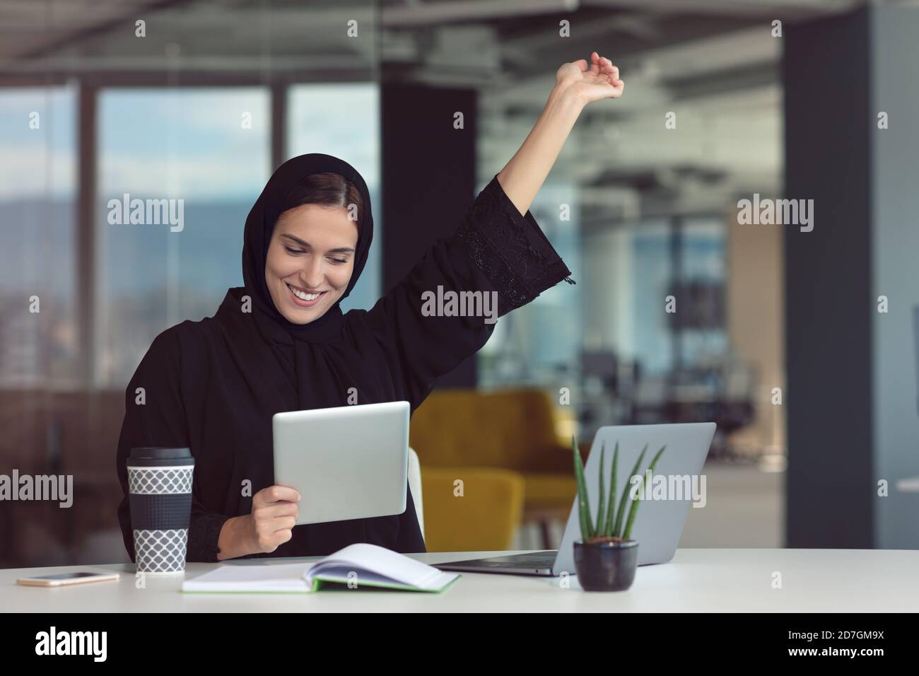 Professionelle junge muslimische Geschäftsfrau mit mobilen digitalen Tablet-Computer bei der Arbeit Stockfoto