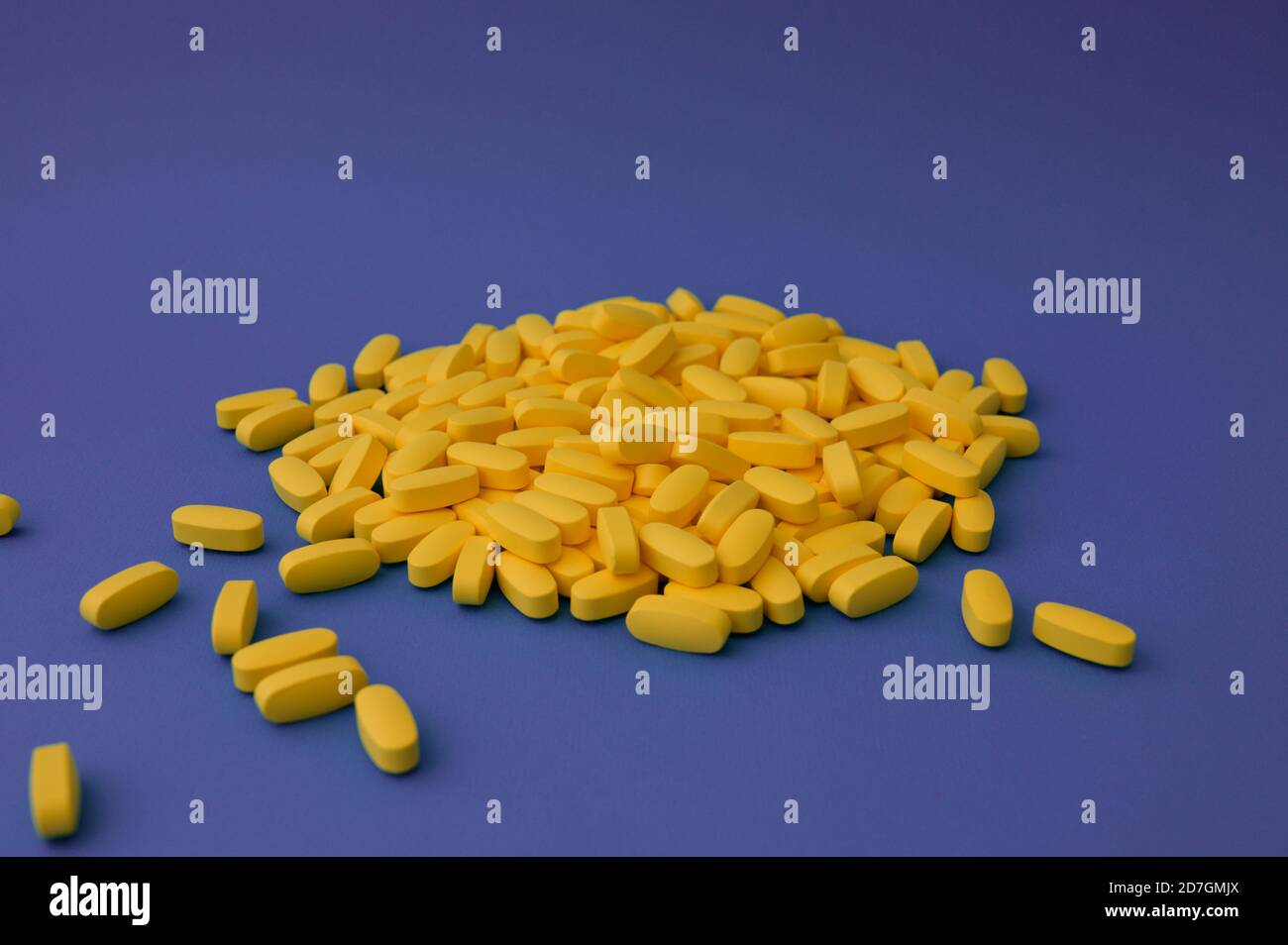 Pharmazie Industrie Produktionskonzept viele gelbe Pillen Tabletten Vitamin on Violetter violetter Hintergrund Stockfoto