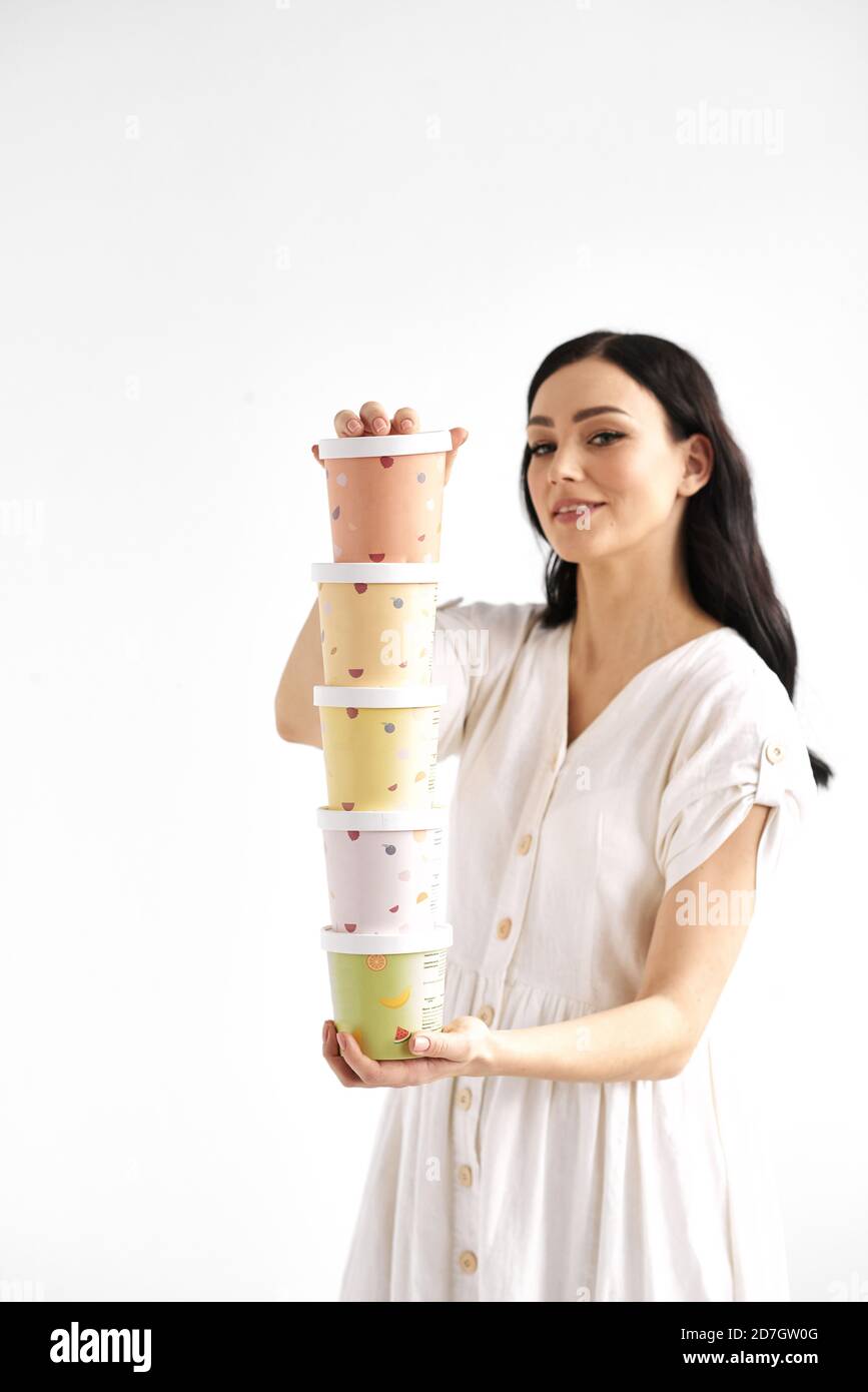 Mädchen hält einen Turm aus farbigem Papierkarton. Einweg Öko Geschirr Konzept Stockfoto