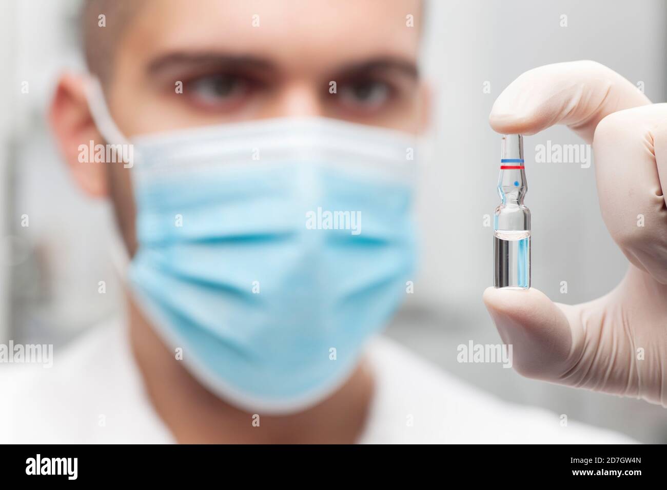 Arzt hält eine Ampulle für die Impfung oder Schönheitsbehandlung in Seine Hand - konzentrieren Sie sich auf die Ampulle Stockfoto