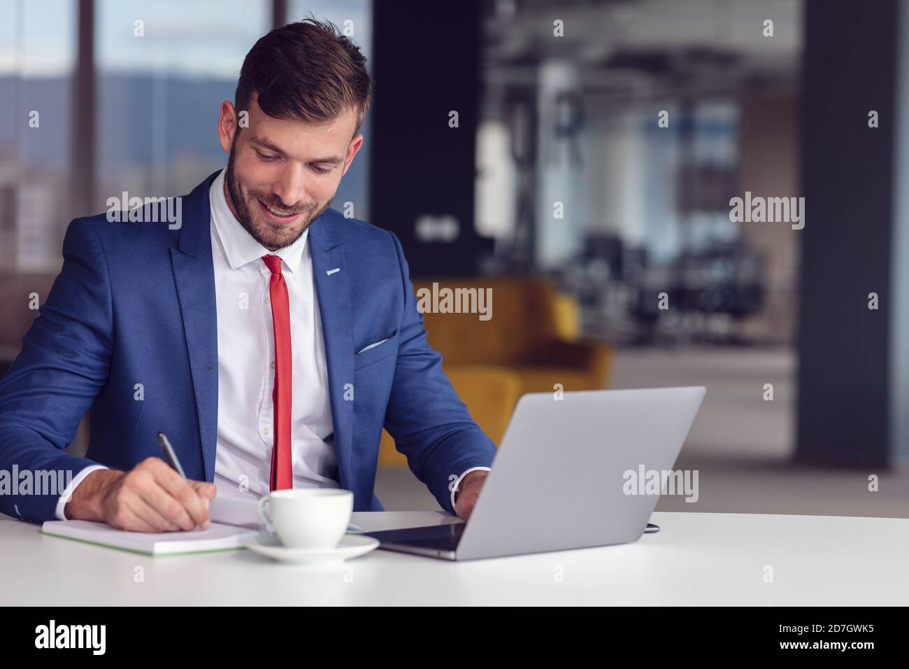 Geschäftsmann im Hemd, der in einem Büro an seinem Laptop arbeitet. Büro mit offenem Raum Stockfoto