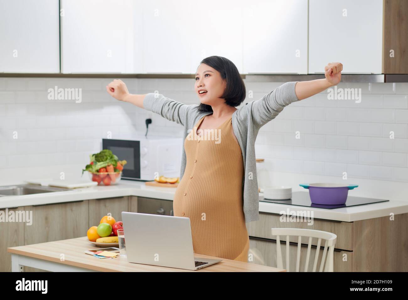 Junge schwangere Frau leidet unter Kopfschmerzen im Home Office Stockfoto