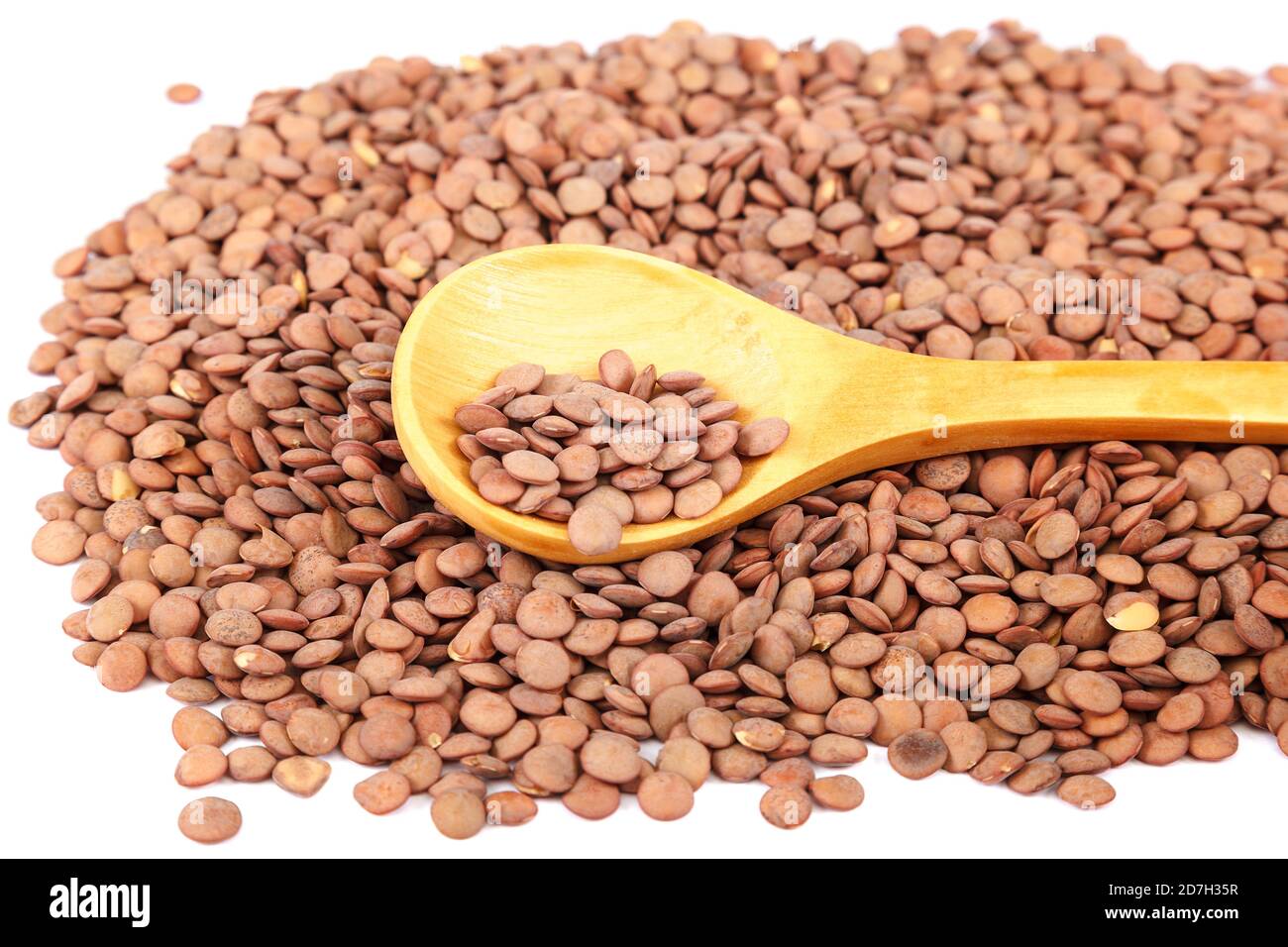 Linsenkörner mit einem Holzlöffel als Hintergrund. Stockfoto