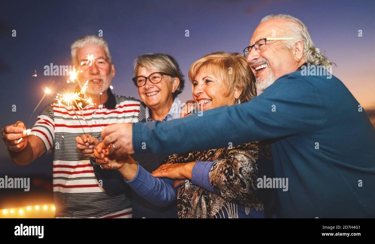 Glückliche ältere Familie feiert mit Sparkler Feuerwerk zu Hause Partei - Ältere Menschen Lebensstil und Urlaub Konzept Stockfoto
