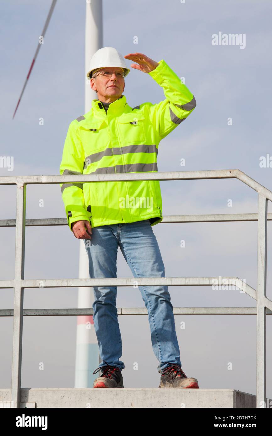 Reifer Ingenieur, der nach einer grünen Zukunft Ausschau halten wird Einer Windkraftanlage - konzentrieren Sie sich auf die Person Stockfoto