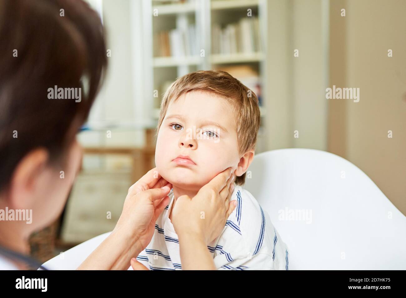Krankes Kind mit geschwollenen Mandeln auf Untersuchung beim Kinderarzt Stockfoto