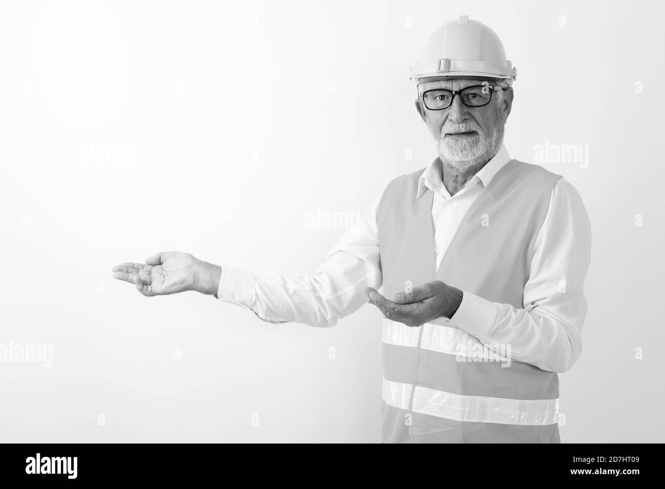 Studio geschossen von Stattlichen älteren bärtigen Mann Bauarbeiter etwas zeigen beim Tragen von Brillen vor weißem Hintergrund Stockfoto