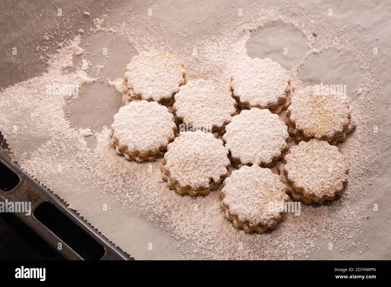 Weihnachtsbacken: Deutsche Marmeladenkekse (Spitzbuben) mit Zuckereier auf Backpapier Stockfoto