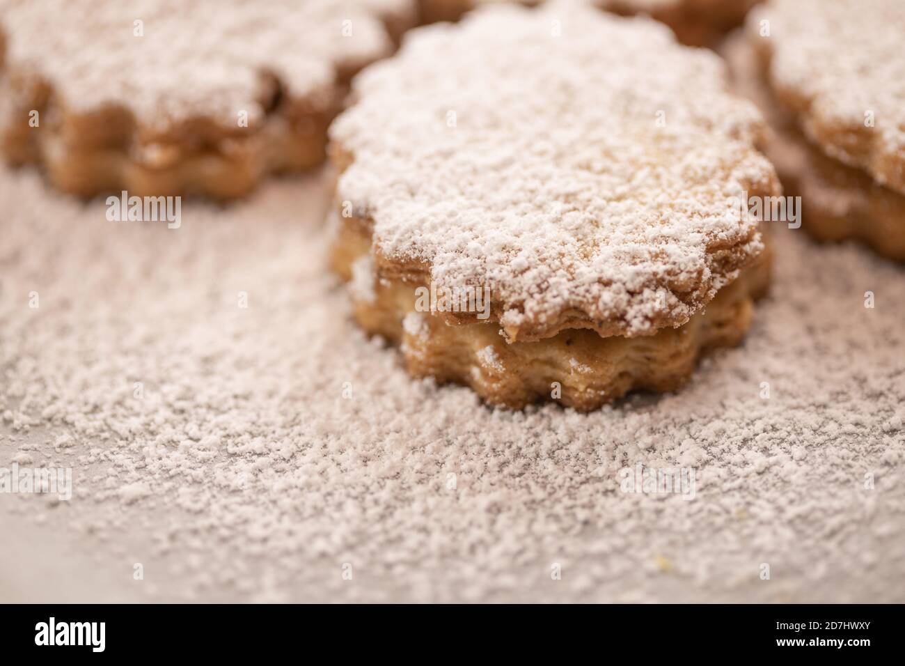 Weihnachtsbacken: Nahaufnahme von Spitzbuben mit Zuckereier auf Backpapier Stockfoto