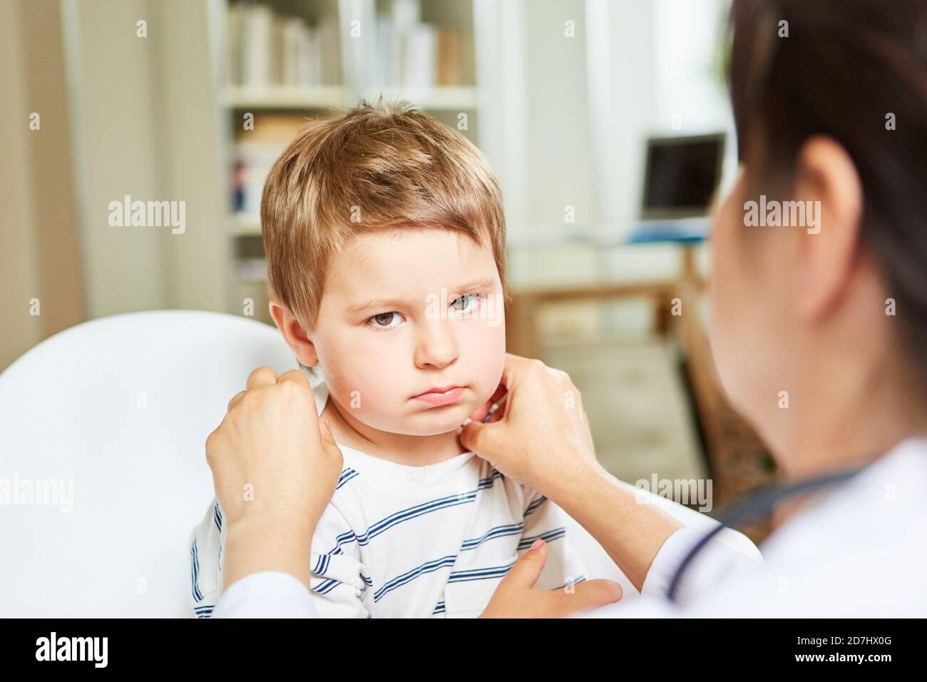 Kinderarzt palpates Mandeln und Lymphknoten bei einem Kind mit Tonsillitis Stockfoto