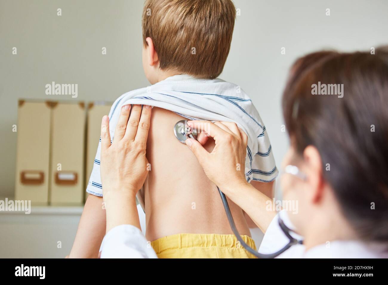 Kinderarzt mit Stethoskop, das auf die Lungen beim Kind mit hört Bronchitis und Husten Stockfoto