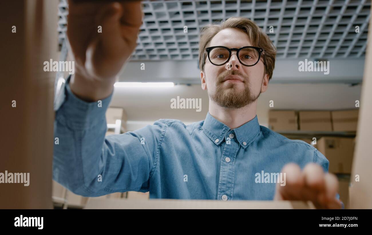 Ansicht von innen Karton-Paket-Box: Lagerarbeiter sorgfältig verpacken Produkt für die Lieferung, Sicherung mit Bubble Wrap. Stockfoto