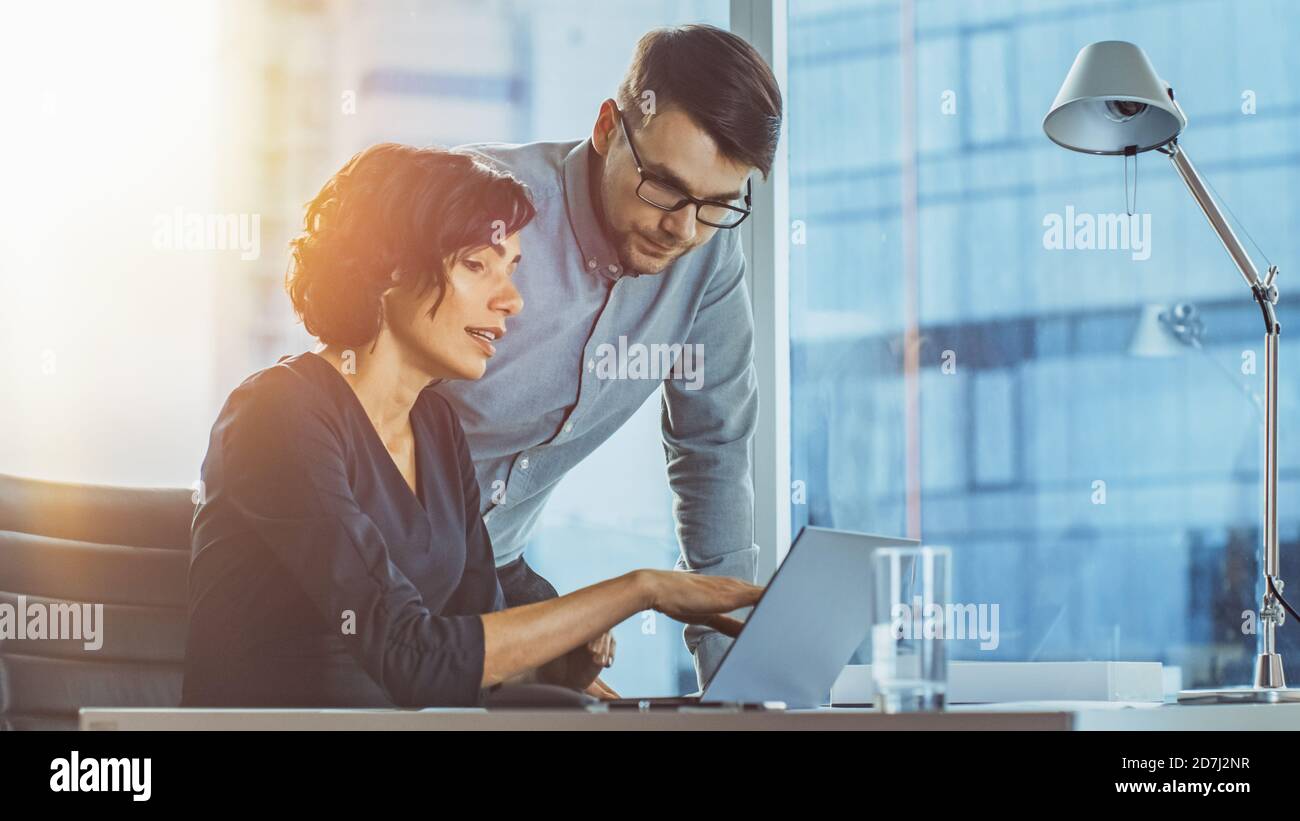 Schöne Geschäftsfrau, die an ihrem Schreibtisch im Büro mit Blick auf die Stadt stattfindet. Erfolgreiche Frau Trägt Formelle Kleidung Kleid Arbeiten Stockfoto