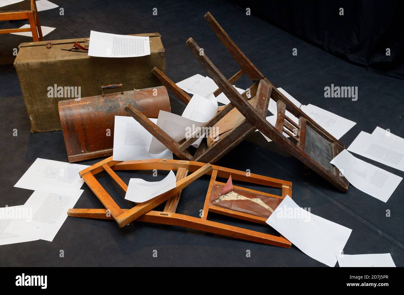Altmodische Stühle, Truhen und Papierstücke, die auf einer Theaterbühne in Unordnung gebracht wurden Stockfoto