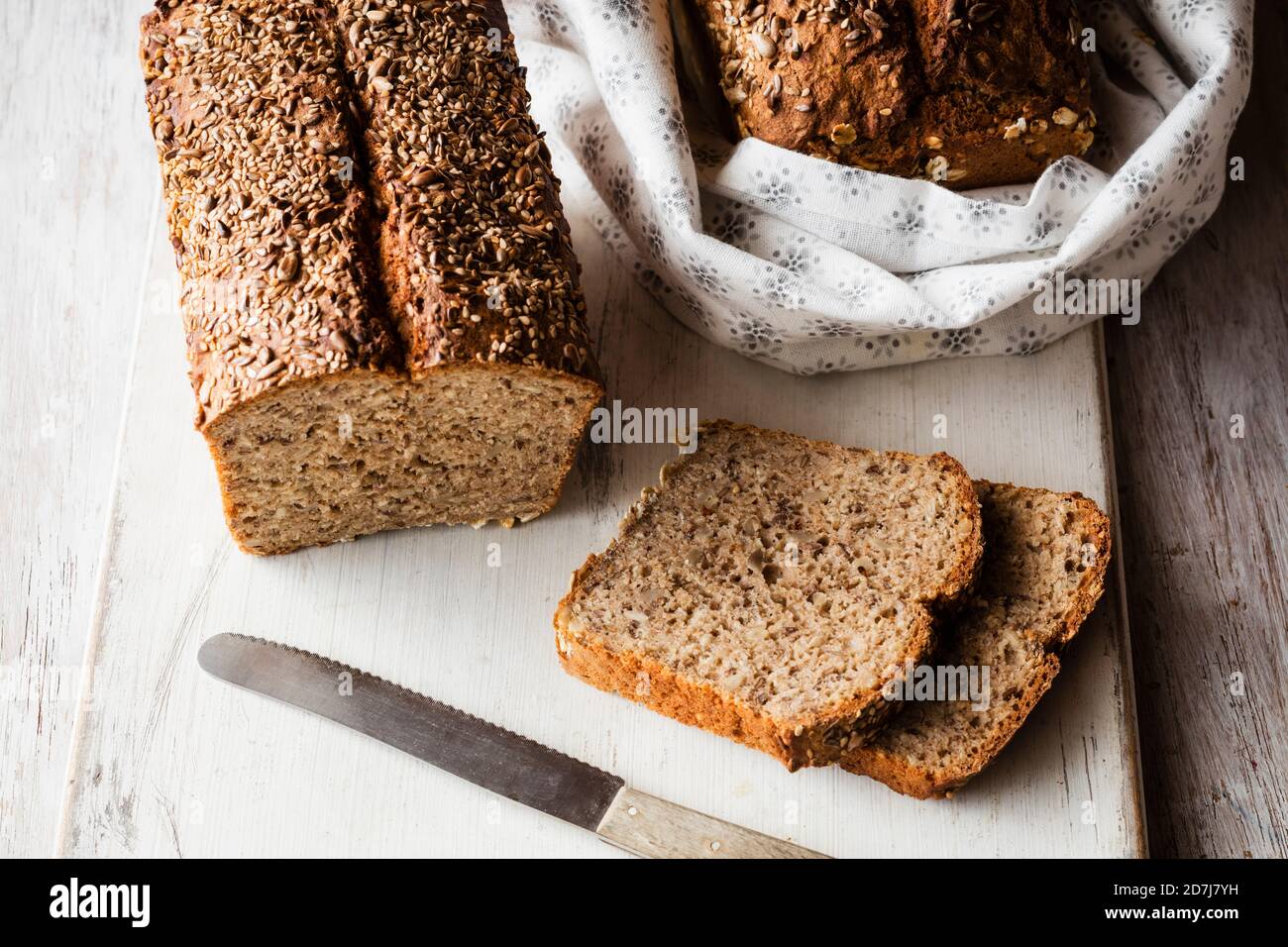 Hausgemachte Buchweizenbrot und Scheiben auf Schneidebrett gehalten Stockfoto