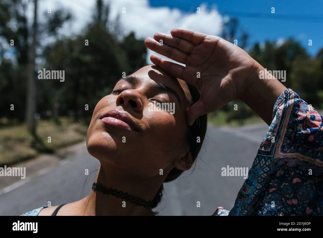 Nahaufnahme einer jungen Frau mit geschlossenen Augen, die auf der Straße steht An sonnigen Tagen Stockfoto
