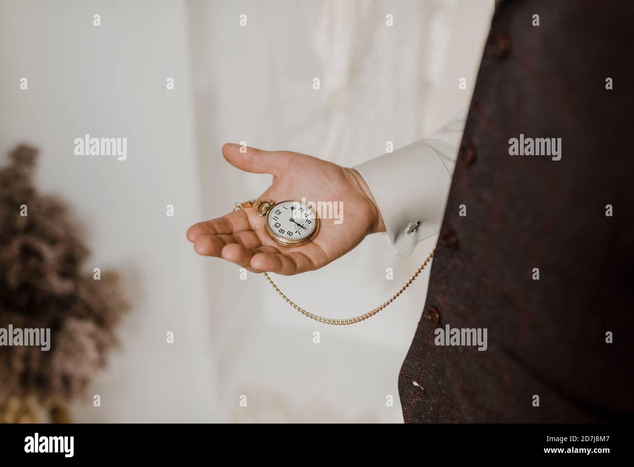 Mittelteil des Bräutigams mit Kettenuhr in der Hand Stockfoto