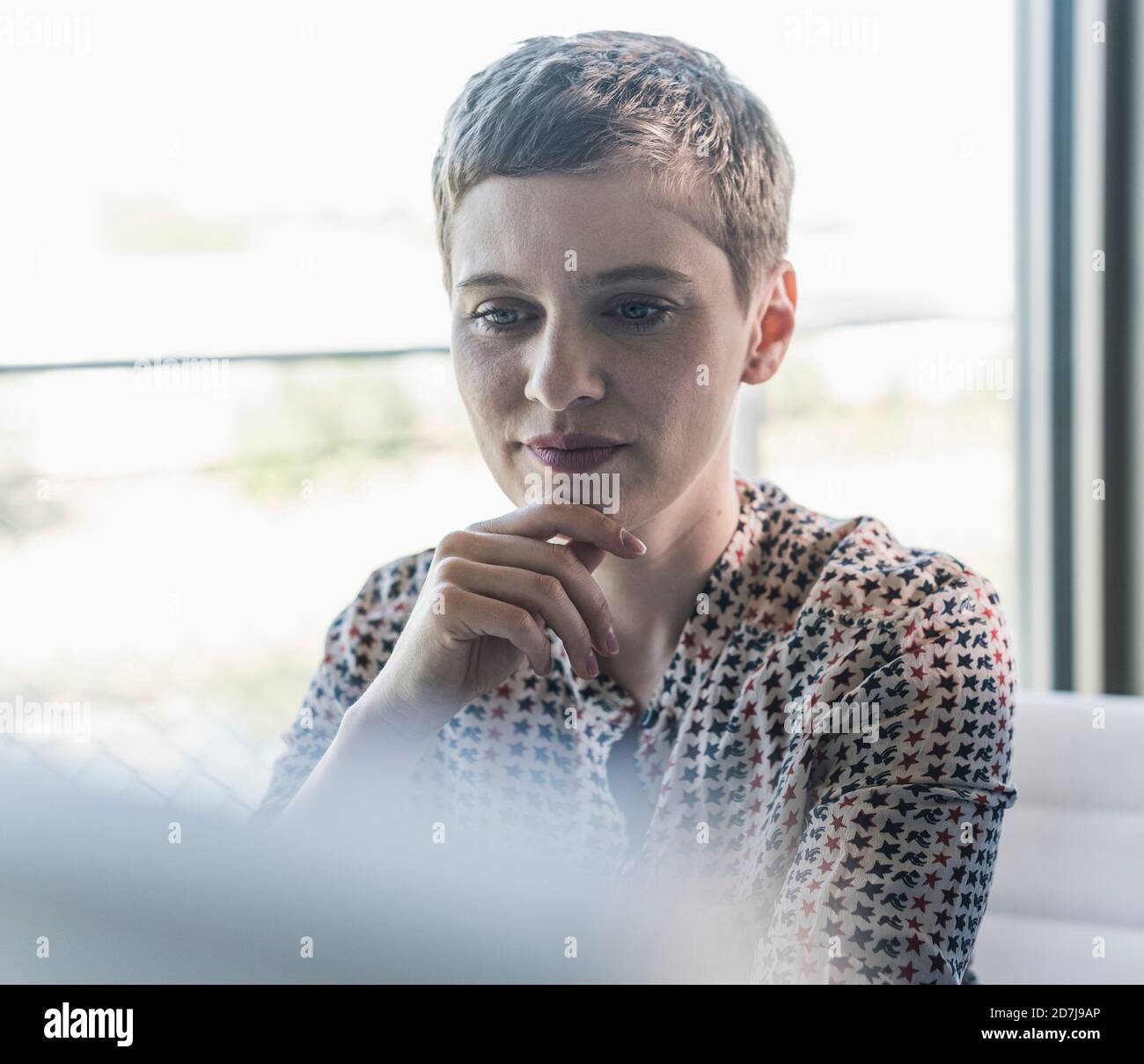 Nahaufnahme einer durchdachten Geschäftsfrau mit kurzen Haaren im Büro Stockfoto