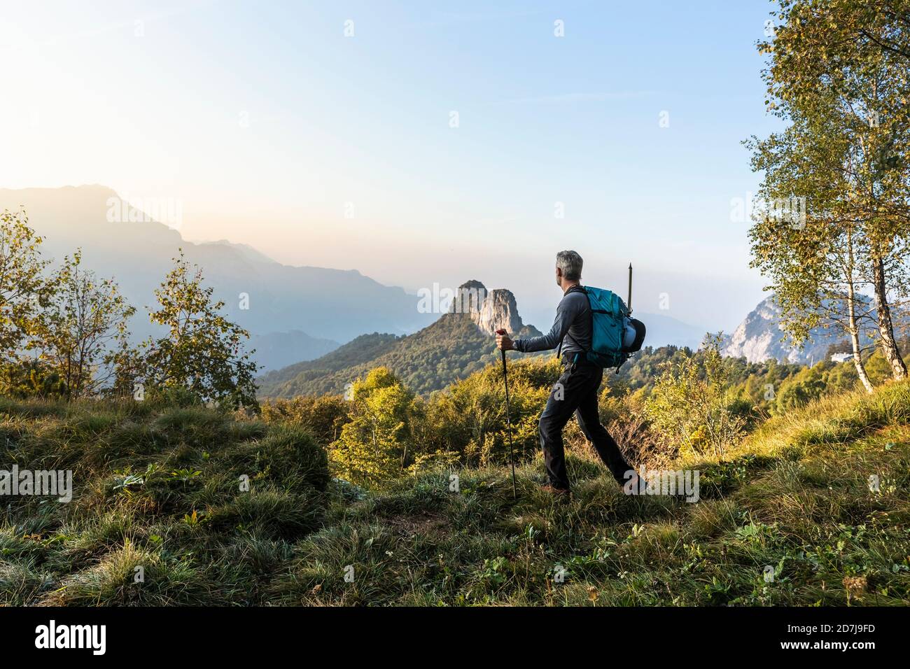 Männlicher Wanderer, der während des Sonnenaufgangs auf dem Berg gegen den Himmel läuft, Orobie, Lecco, Italien Stockfoto