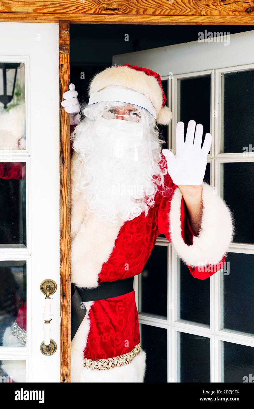 Mann im Weihnachtsmann Kostüm mit Stoppschild im Stehen Am Eingang des Hauses Stockfoto