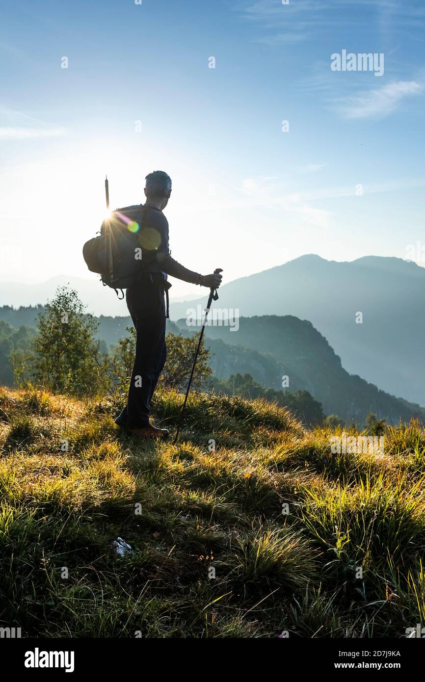 Silhouette männlichen Wanderer Blick auf die Ansicht, während auf dem Berg während Sonnenaufgang stehen, Orobie, Lecco, Italien Stockfoto