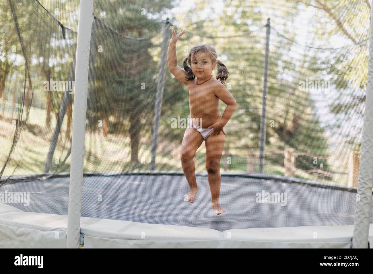 Mädchen stehend während des Spielens im Trampolin Stockfoto