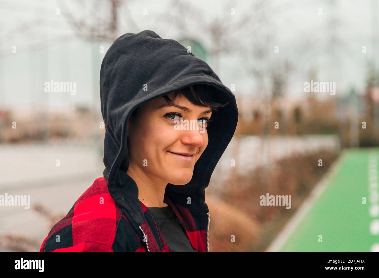 Porträt einer jungen Frau mit Kapuze lächelnd an der Kamera Stockfoto