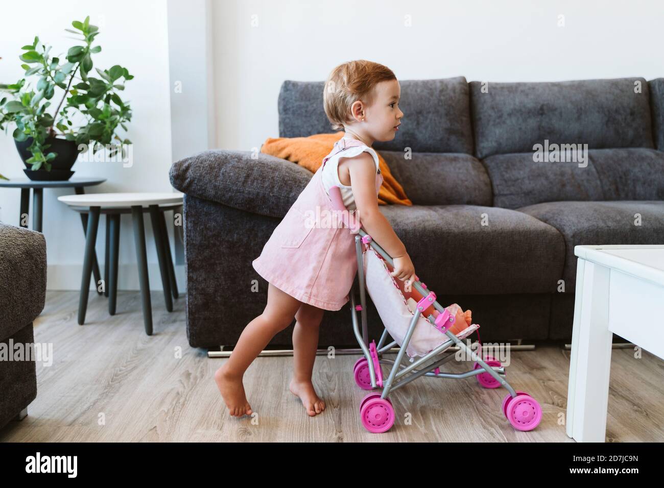 Baby Mädchen spielen mit Spielzeug und Baby Kinderwagen zu Hause Stockfoto