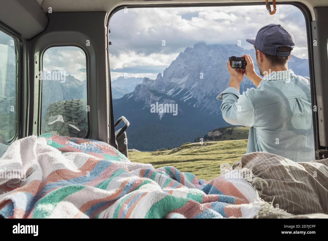 Mann fotografiert malerische Bergketten, während er am Wohnmobil steht. Sextner Dolomiten, Dolomiten, Südtirol, Italien Stockfoto