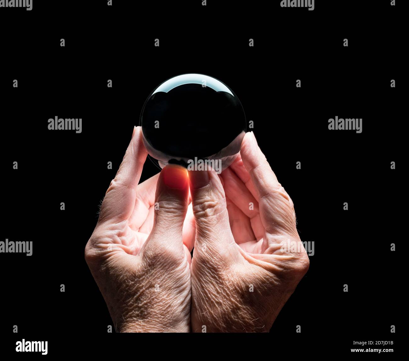 Ältere kaukasische Hände halten eine Kristallzukunft oder Wahrsagerei Ball mit schwarzer Mitte, um das Compositing Ihres Logos zu ermöglichen Stockfoto