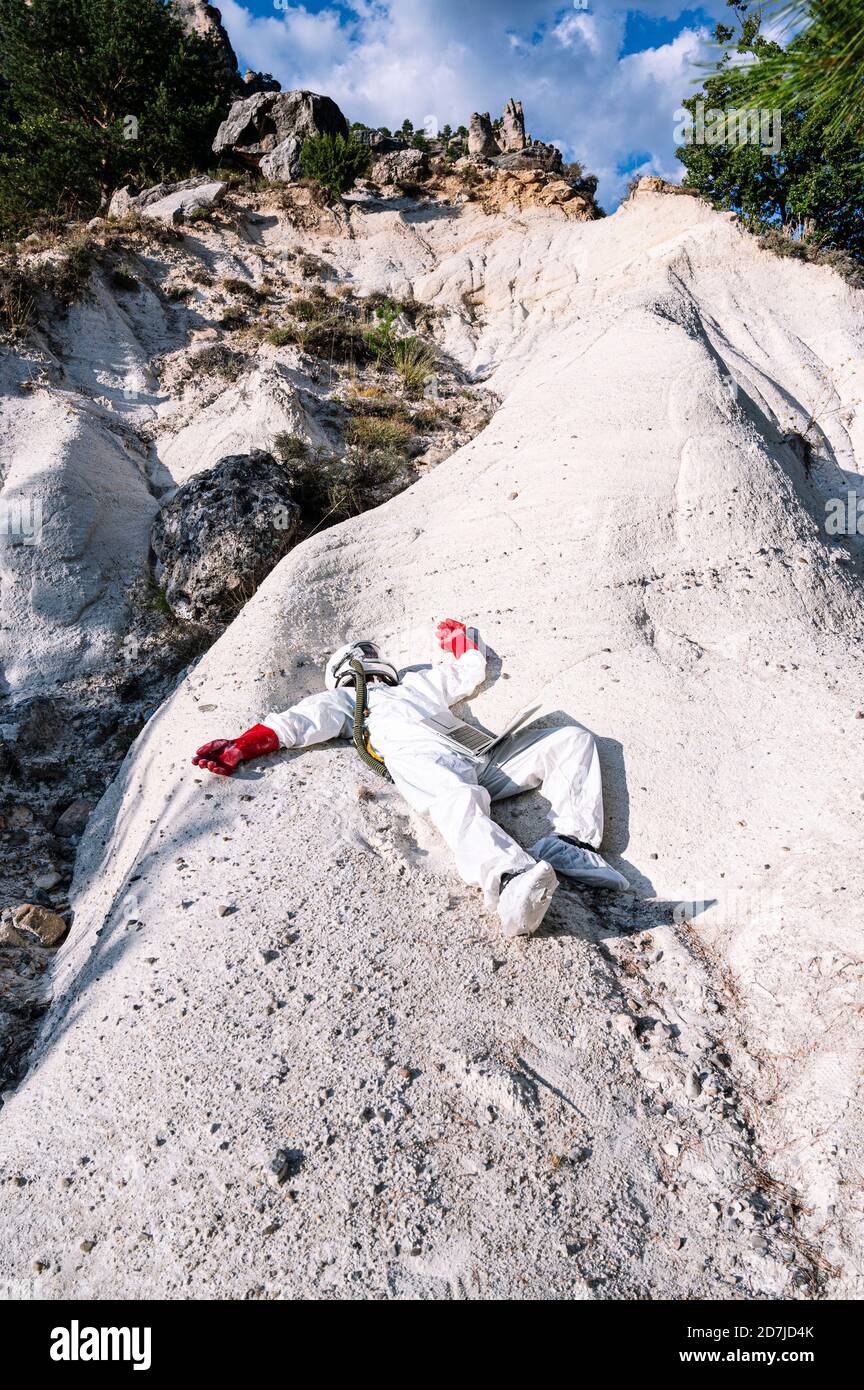 Männlicher Astronaut liegt auf dem Berg Stockfoto