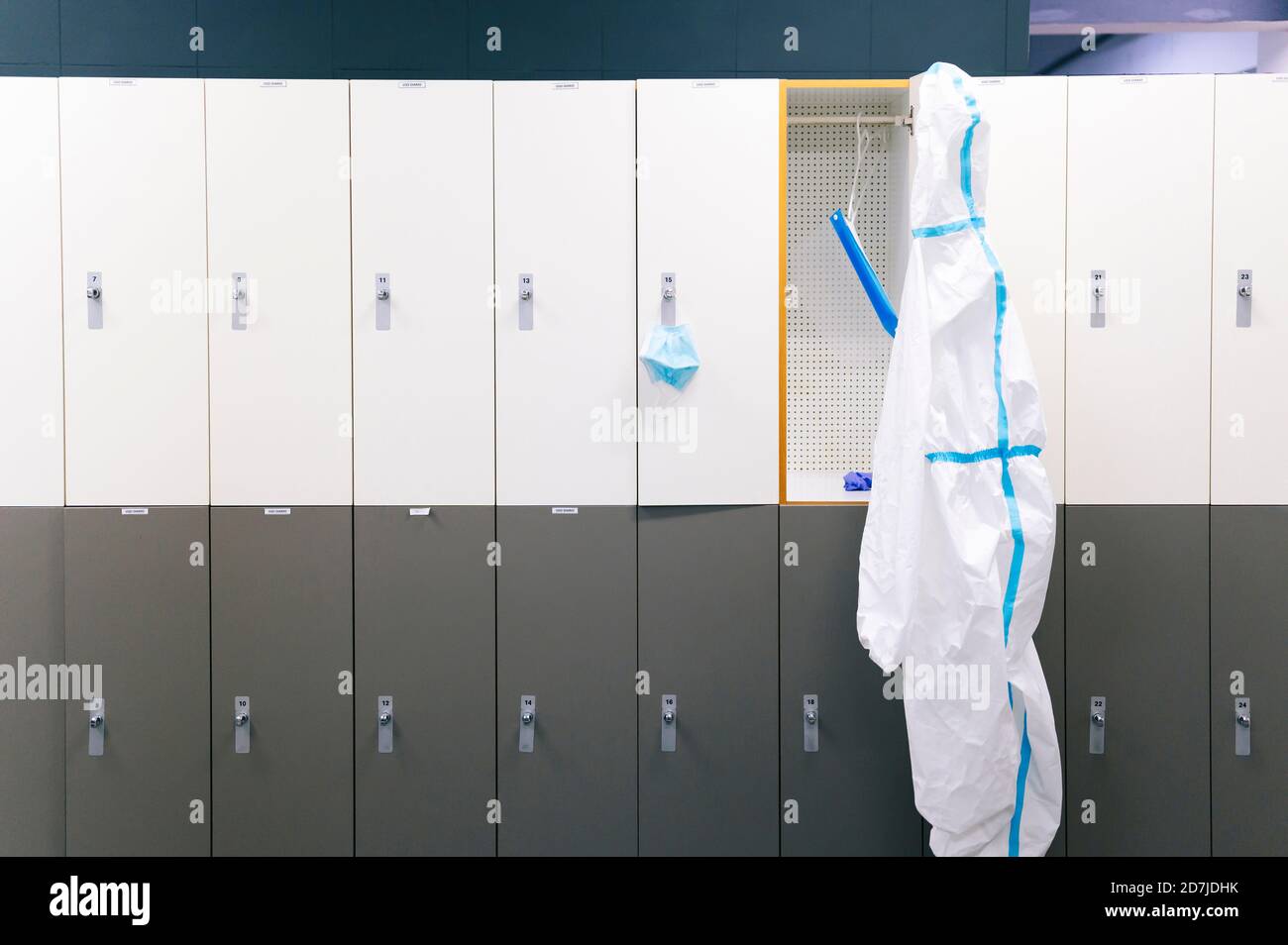 Schutzkleidung und Gesichtsschutz hängen an Spind im Krankenhaus Stockfoto